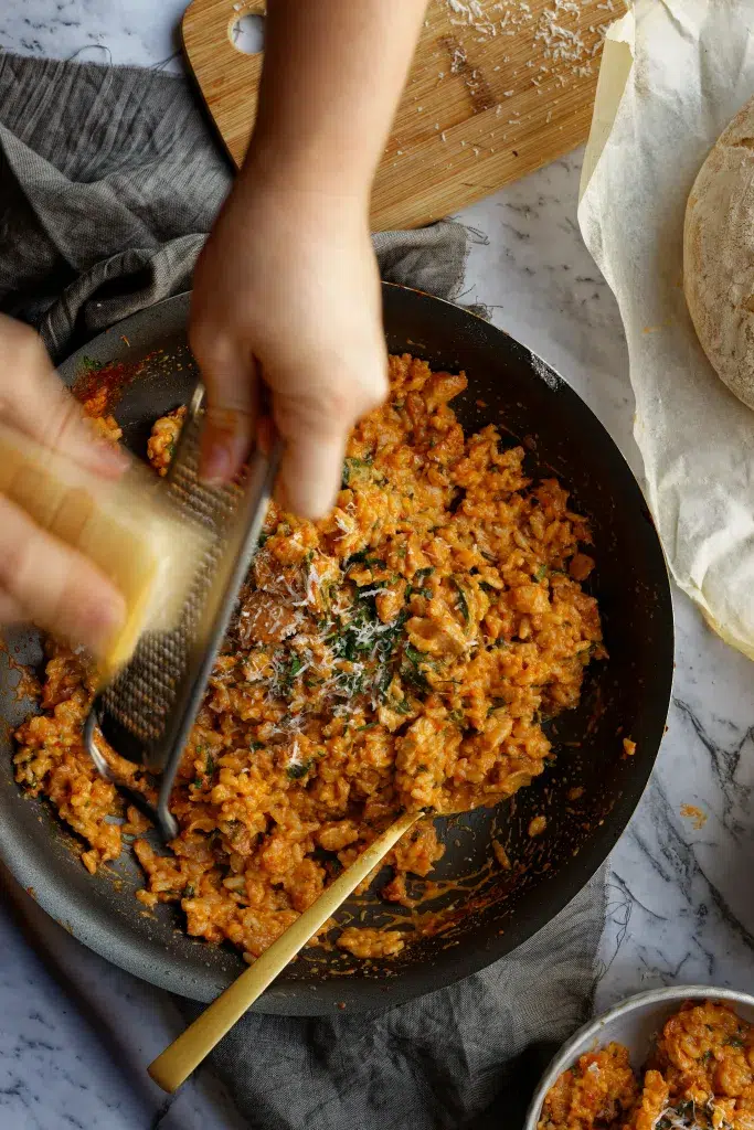 Slow Cooker Chicken & Chorizo Risotto: The Effortless Comfort Dish You’ll Crave Again, freshly cooked in a skillet with creamy rice, tender chicken, smoky chorizo, and grated parmesan cheese on top.
